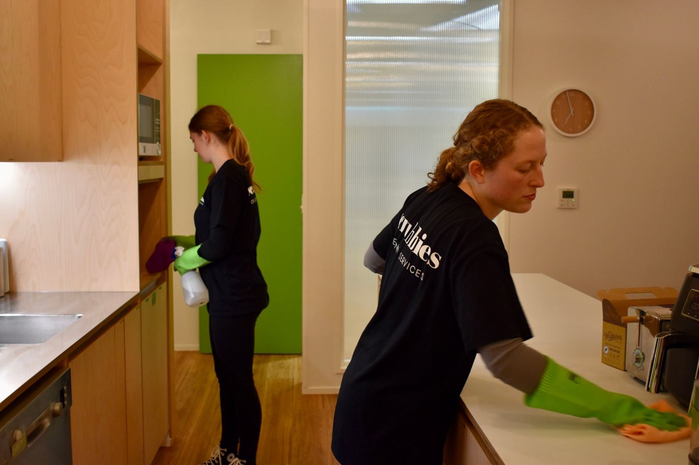 Two Scrubbies cleaners wiping down an office kitchen