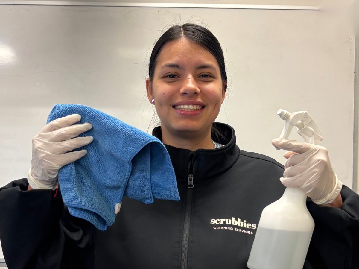 Smiling Scrubbies cleaner holding a cloth and spray bottle